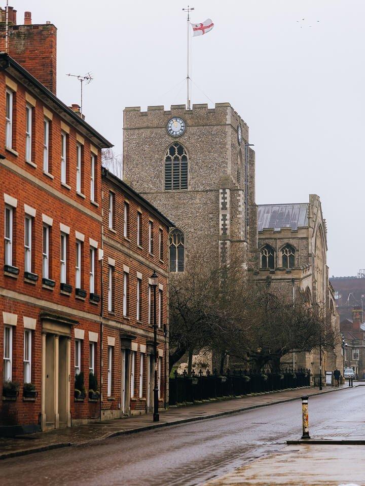 a street with a clock tower and a church on the other side